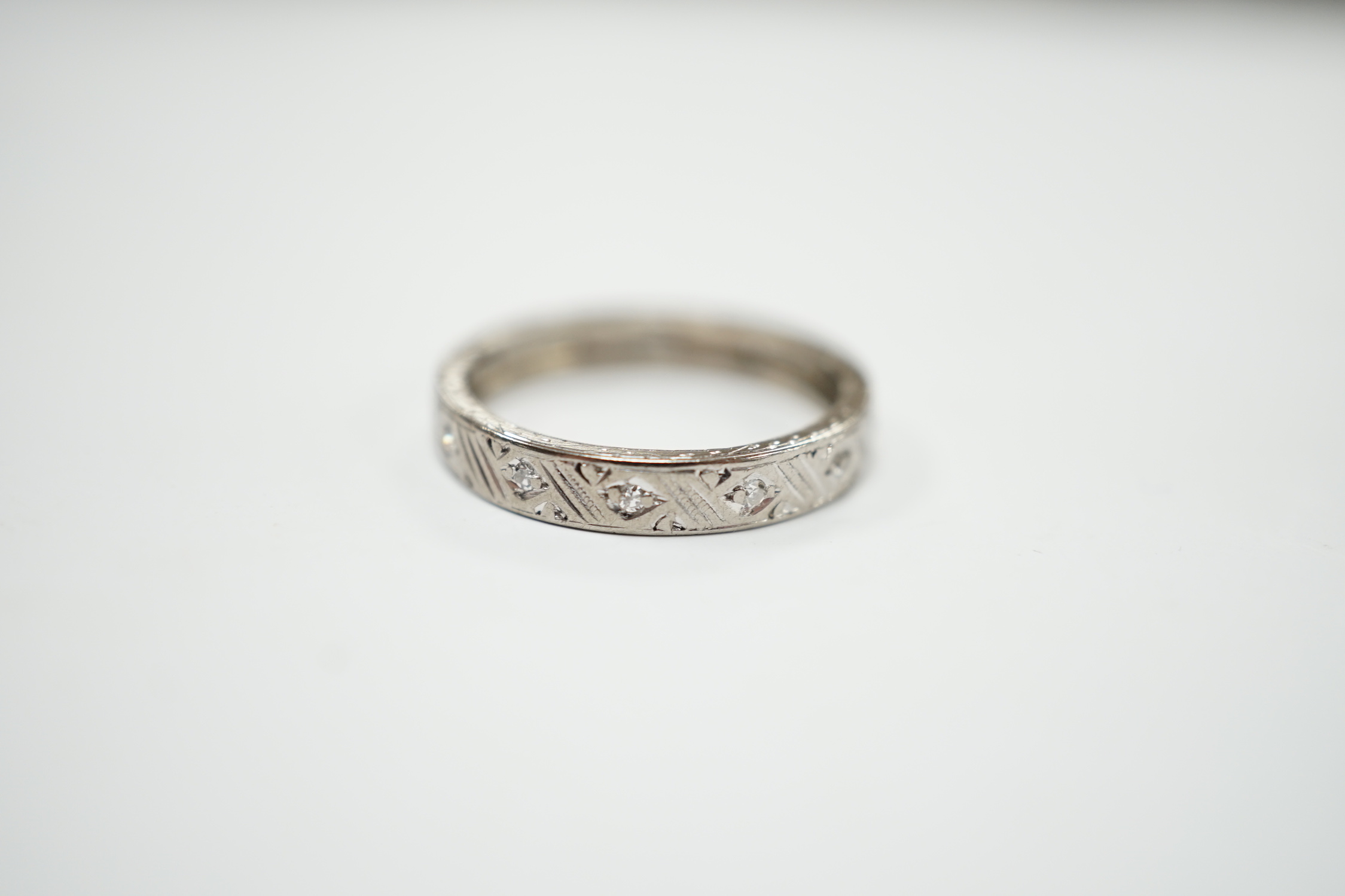 An 18ct white metal and diamond chip set full eternity ring, size K, gross weight 3 grams.